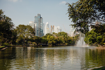 Lumpini Park Lake with Fountain and Modern Bangkok Skyline