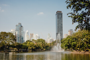 Lumpini Park Lake with Fountain and Modern Bangkok Skyline