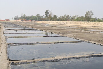 Fototapeta premium raw salt farm plot with water and polythene bed