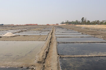 Fototapeta premium raw salt farm plot with water and polythene bed