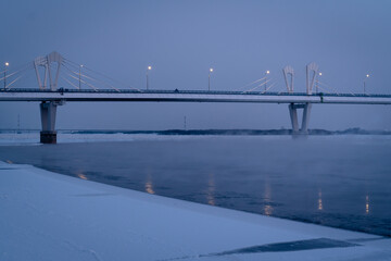 Winter view of an Illuminated bridge crossing the Zeya River in Blagoveshchensk, Russia.