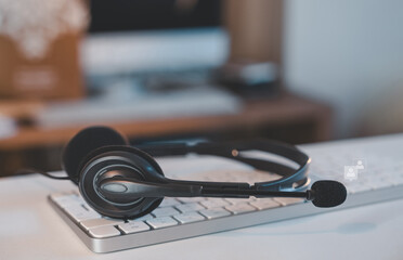 Customer service headset with microphone on computer keyboard and user icon overlay, representing online communication, remote support, help desk, call center, client service, and virtual teamwork.