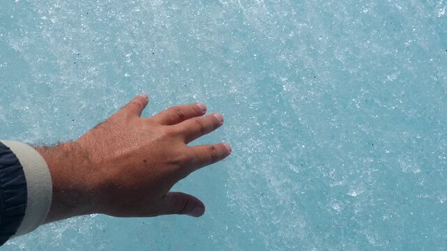 Touching ancient ice of athabasca glacier, capturing fragile connection between human hand and massive columbia icefield landscape in jasper national park