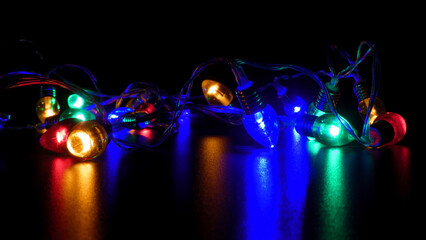 Vibrant Christmas Lights Glowing on Reflective Black Surface