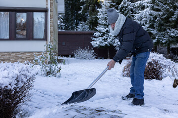 Elderly man shoveling snow in winter park