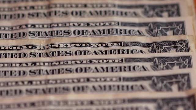 Macro view of one-dollar banknotes arranged in a row, representing the concept of the foreign exchange market and the strength or devaluation of the US dollar.
