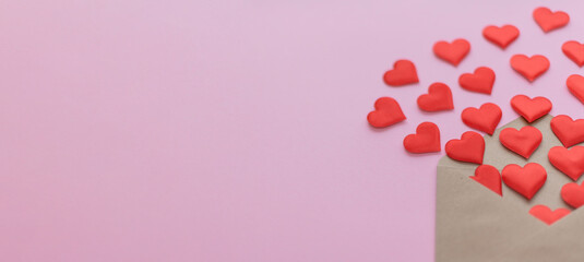 A brown envelope with red paper hearts spilling out against a pink background. The scene conveys themes of love and affection.