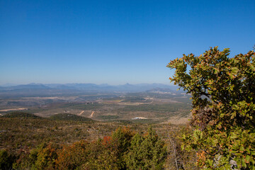 Panoramic view from the top of Mount Križevac in Medjugorje with the iconic cross overlooking the town, a sacred pilgrimage site symbolizing Christian faith, prayer, and spiritual reflection.