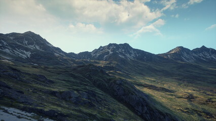 Obraz premium Majestic mountains stretch across the horizon, bathed in soft golden light. The rocky terrain meets lush greenery, creating a harmonious scene that invites exploration and adventure.