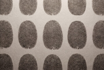 Pattern of black fingerprints on a light beige background, creating a repetitive and organized texture.