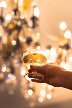 Champagne "coupe"glass held in front of an old chandelier