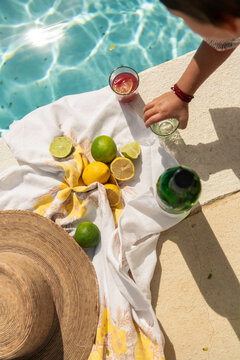 Hand reaching for poolside drink on sunny day