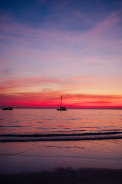 Pink and Purple Sunset Over Calm Sea with Sailboats on Koh Chang