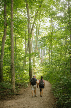 Young couple holding hands walking forest trail at Turkey Run