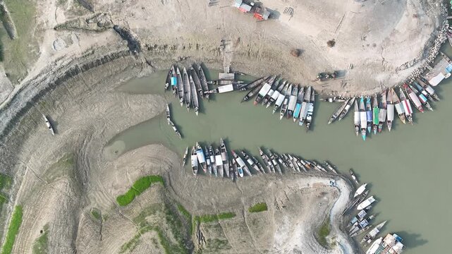 Top View of Wooden Boats Docked Along a Narrow River Channel During Dry Season - 4k smooth video footage