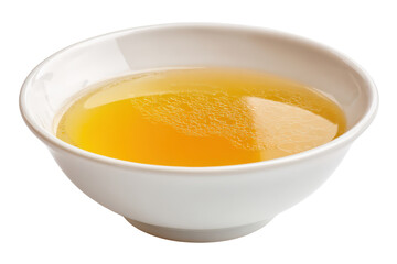 White bowl filled with golden yellow chicken broth on black background soup