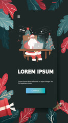 Santa online shopping Christmas New Year 2026 festive scene Santa using laptop at desk with decorated tree credit cards gifts modern mobile app screen