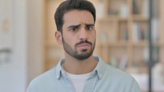 Confused Man Expressing Doubt and Uncertainty with Gestures and Facial Expressions.