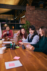 Creative team working together at modern coworking table. Concept of collaborative office culture, teamwork workflow, shared ideas, creative business environment and productive meeting.