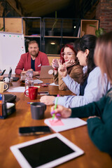 Coworkers focusing on tasks during creative team meeting. Concept of productive office routine, shared focus, teamwork balance and modern coworking workflow.