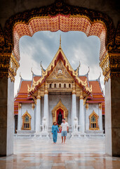 Stunning architecture of Wat Benchamabophit in Bangkok, with visitors exploring the temple grounds