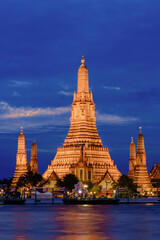 Naklejka premium Stunning Wat Arun illuminated at twilight along the Chao Phraya River in Bangkok