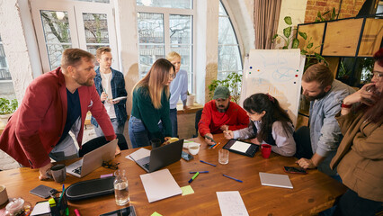 Startup team working together around table in modern office. Concept of creative startup teamwork,...