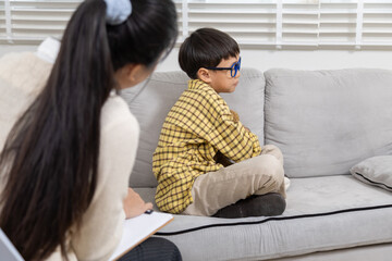 Therapy, child, counseling, psychologist, emotion reflected in withdrawn posture, boy holding...