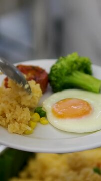 Nasi Berkat is rice with side dishes of beef rendang, crispy tempeh, egg, caramelized potato chip, and steamed mixed vegetable.