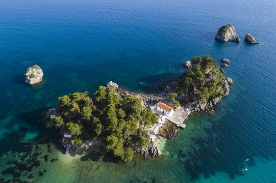 Aerial view of a small island with a church, surrounded by turquoise waters, a serene escape captured from above, Panagia, Thasos Regional Unit, Greece.