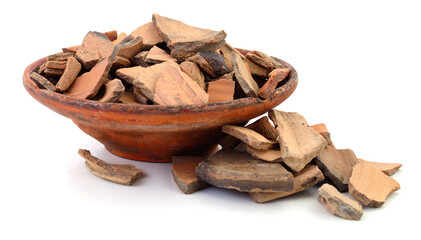 Broken pieces of ancient pottery in a clay bowl isolated on white