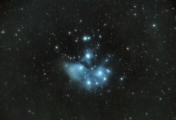 Stunning view of the Pleiades star cluster (M45) with blue reflection nebula glowing around bright stars in deep space