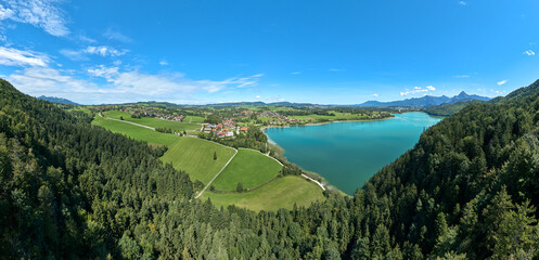 aerial photo of the alpine landscape at lake Weissensee and village of Oberkirch in the eastern Allgaeu near city of Fuessen, Bavaria, Germany
