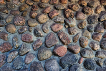 fragment of aged stone grey-brown colors wall, abstract natural texture background. old stone wall made of rough wild cobblestones. template for design