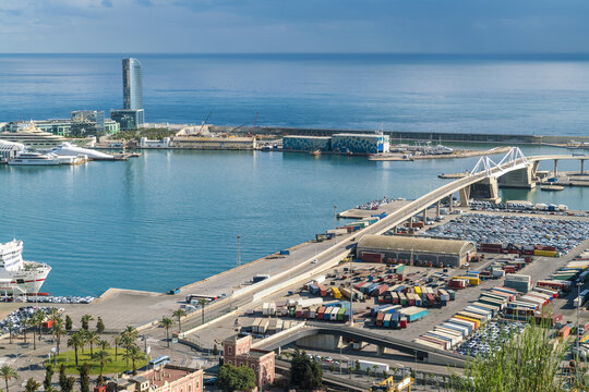 Barcelona, Spain - 07 November 2016: Aerial view of the W Barcelona hotel reflecting the azure sky, contrasted against the bustling port and bridge.