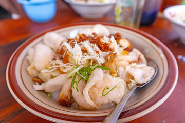 Indonesian chicken porridge, famous local street food made from rice cooked in plenty of water to...