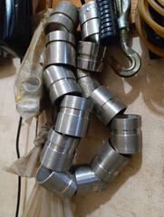 Shiny Metal Machined Parts Stacked and Hanging in a Workshop