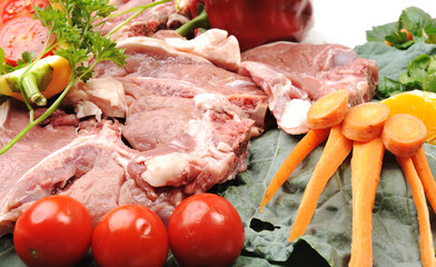 Sliced meat with sauce on board with vegetables