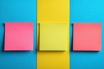 Fototapeta premium Vibrant colored sticky notes on blue and yellow background for organization