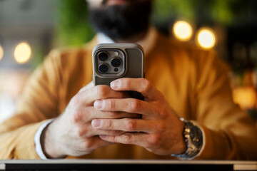 Close up of hands typing messages on cellphone.