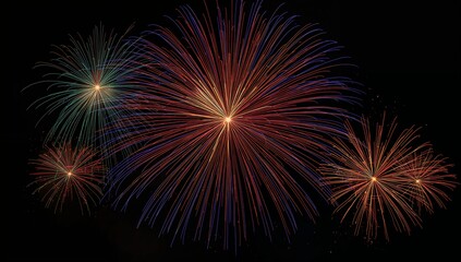 Bursting central multicolor firework over dark night sky, showing teal and orange side bursts