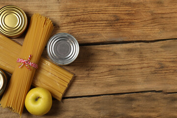 Humanitarian aid. Different food products for donation in crate on wooden table
