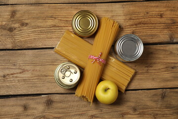 Humanitarian aid. Different food products for donation in crate on wooden table