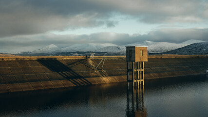 storm clouds over the dam and snowy hills