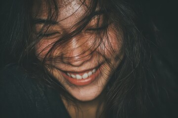 Young Asian woman smiling softly, showcasing joy amidst struggles with mental health in an intimate and close-up setting