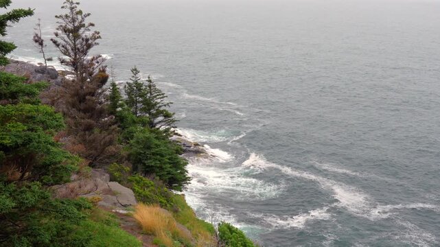 Waves from the ocean rolling in towards the rocky shoreline on the Maine coast.