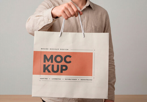 Person holding shopping bag mockup
