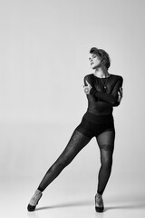 Black and white portrait of a tattooed woman in sheer clothing and patterned tights