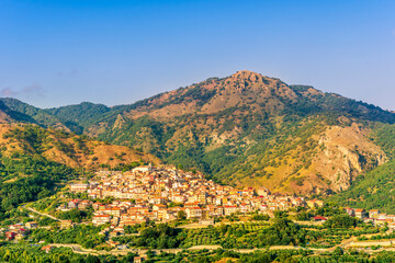 Obraz premium highland landscape of italian town between amazing green mountains with scenic sunset cloudy sky on background