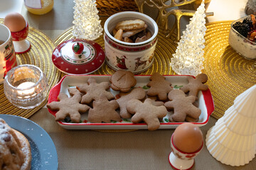 Various of Christmas sugar cookies in variety shape in a plate with holidays decoration atmosphere and candle light, with festive ambiance. 